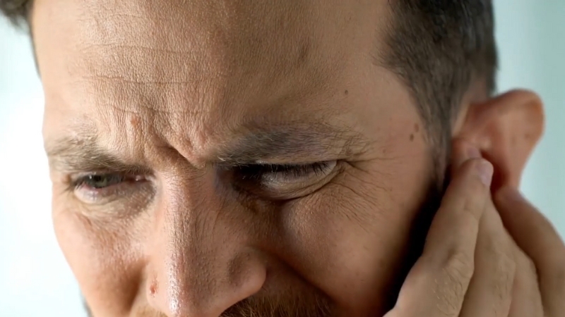 A Man Is Holding His Ear in Discomfort, Possibly Due to Pain Caused by His Wisdom Teeth